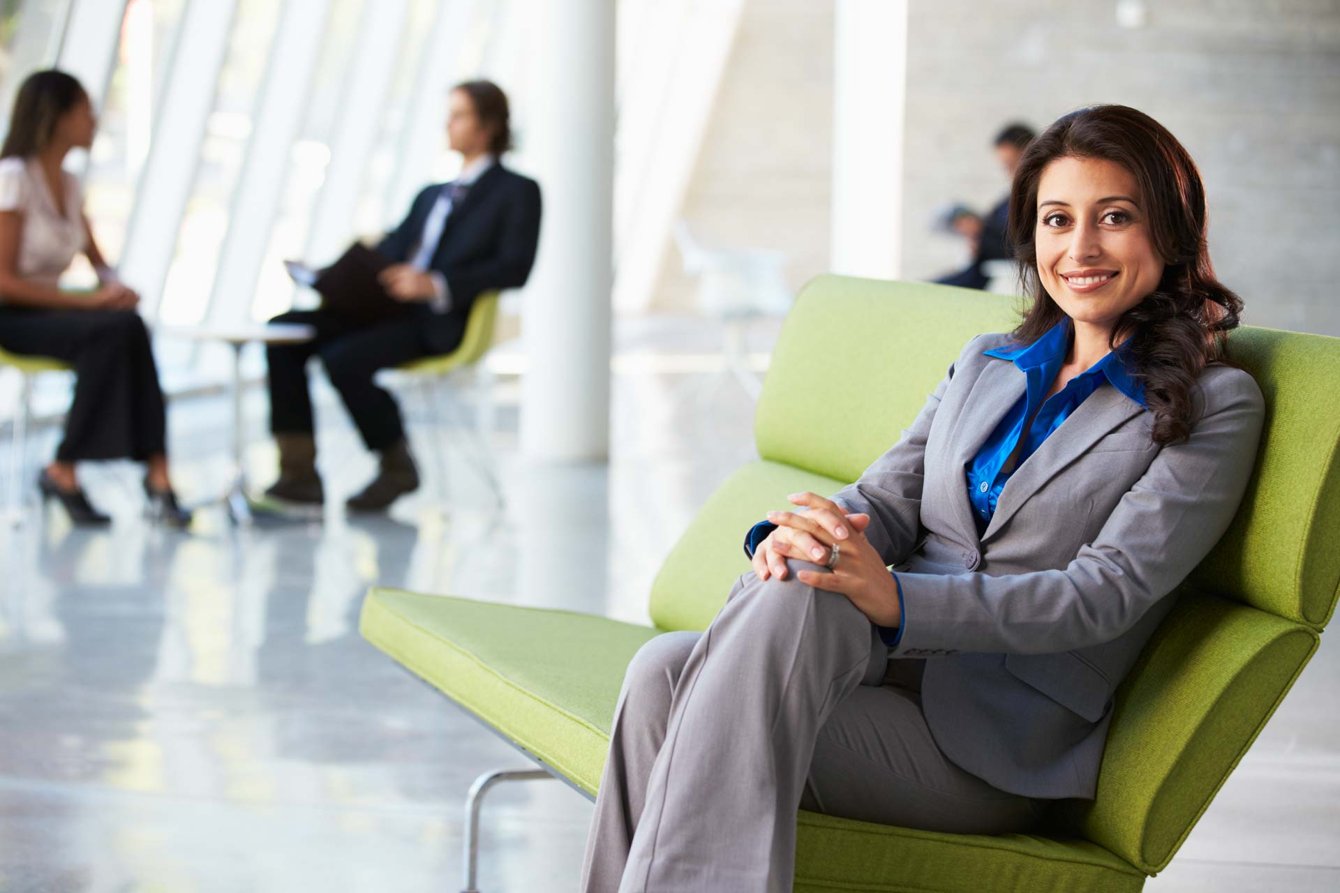 Portrait Of Businesswoman Sitting On Sofa In Modern Office